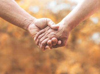 Two holding hands against blurry background