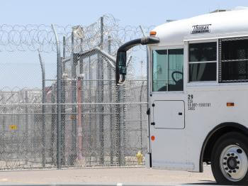 Government bus approaching detention center gates