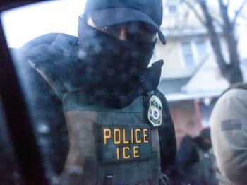 POV inside car showing masked ICE agent at window