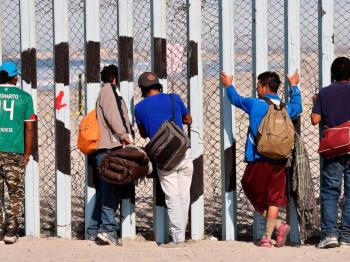 immigrants at border fence